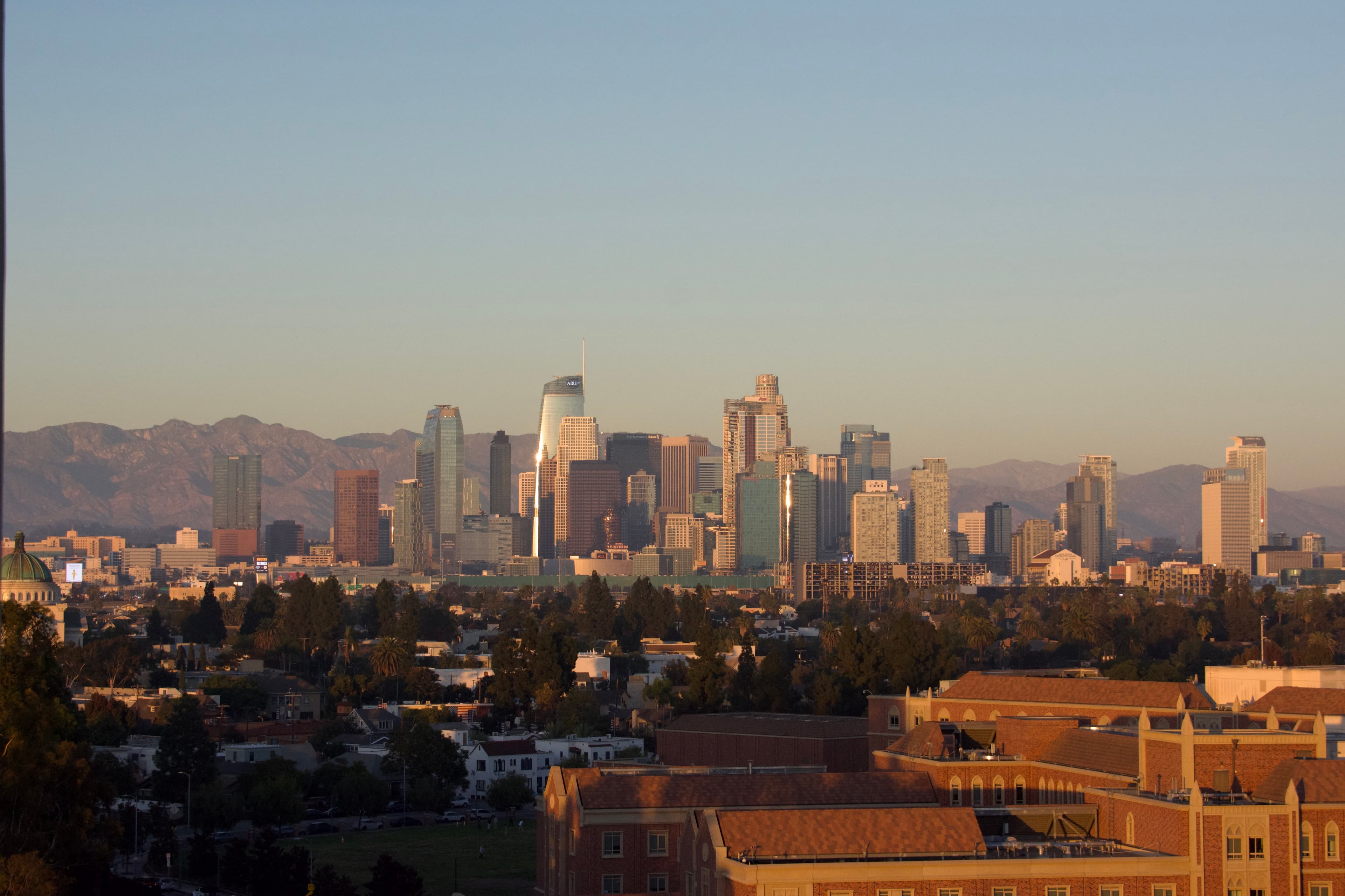 Los Angeles skyline at golden hour with USC campus in the foreground